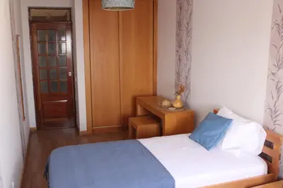 a small bedroom with a bed and a wooden door at brISA in Praia