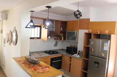 a kitchen with wooden cabinets and a stainless steel refrigerator at brISA in Praia