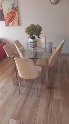 a glass dining room table with chairs and a vase with a plant at Relache House Praia in Praia