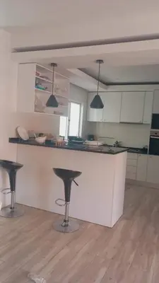 a kitchen with three bar stools in a room at Relache House Praia in Praia