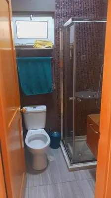 a bathroom with a toilet and a glass shower at Relache House Praia in Praia