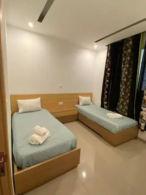 two beds in a room with towels on them at Infinito house in Praia