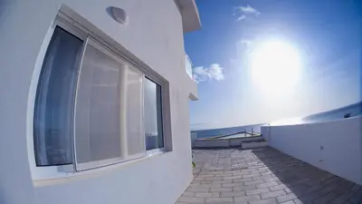 a balcony of a building with a large window at Cacimba Sunset Lodge in Tarrafal