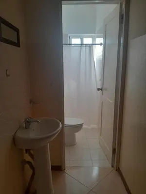 a white bathroom with a toilet and a sink at Casa Magui de Reis in Tarrafal
