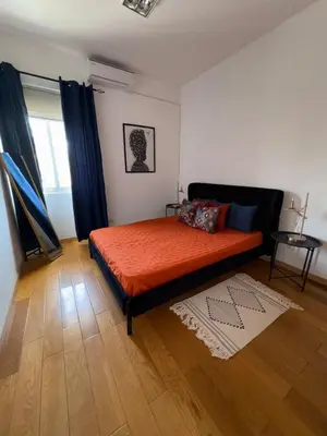 a bedroom with a bed with orange sheets and a window at Prainha Beach House in Praia