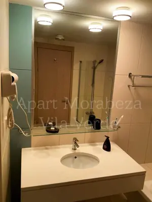 a bathroom with a sink and a large mirror at Morabeza Vila Verde in Santa Maria