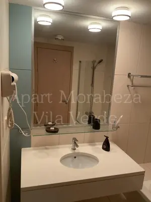a bathroom with a sink and a large mirror at Morabeza Vila Verde in Santa Maria