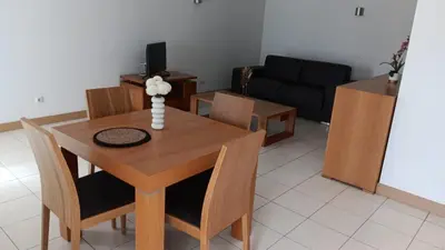 a living room with a table and chairs and a couch at Vila Verde Calistemon in Santa Maria