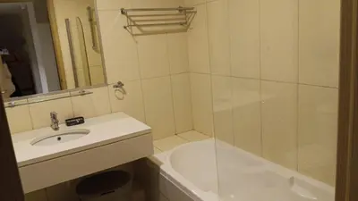 a white bathroom with a sink and a shower at Vila Verde Calistemon in Santa Maria