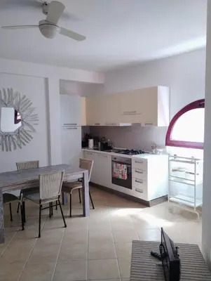 a kitchen with a table and chairs and a dining room at Greta Apartment in Santa Maria