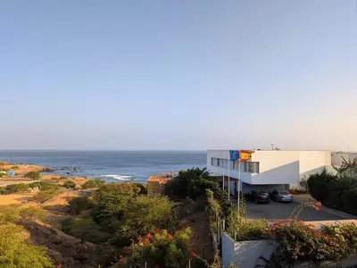 a building on a hill next to the ocean at SeafrontView - Cozy T1 Apartment 1 in Praia