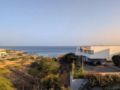 a building on a hill with the ocean in the background at SeafrontView - Cozy T1 Apartment 2 in Praia