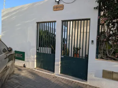 a white building with a green door and fence at SeafrontView - Cozy T1 Apartment 3 in Praia
