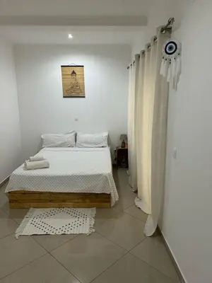 a bedroom with a bed in a white room at Kubiku Guest House in Praia