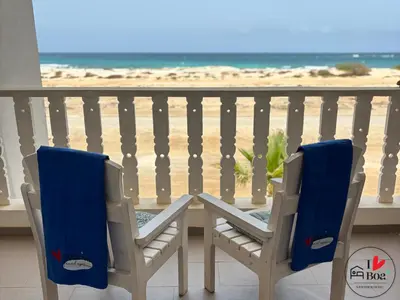 a table and chairs on a balcony with the beach at I LOVE BOA VISTA - Seafront Apartments in Sal Rei