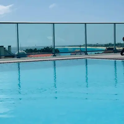 a swimming pool with blue water in front of a building at Sal Little Heart Blue Apartment 13 in Santa Maria