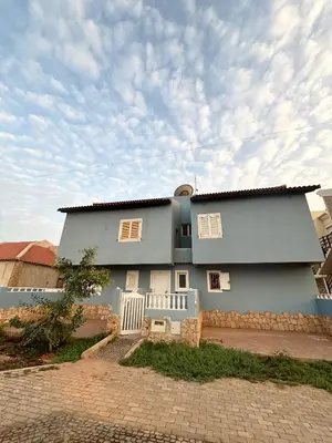 a large blue house with a white fence at Blue Oceano in Santa Maria
