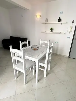 a white table and chairs in a living room at Blue Oceano in Santa Maria