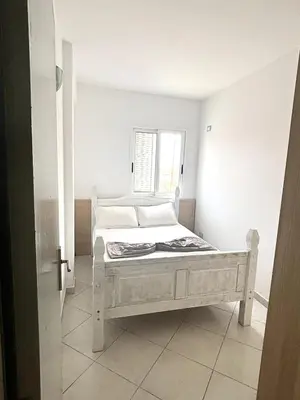 a white bed in a room with a window at Blue Oceano in Santa Maria