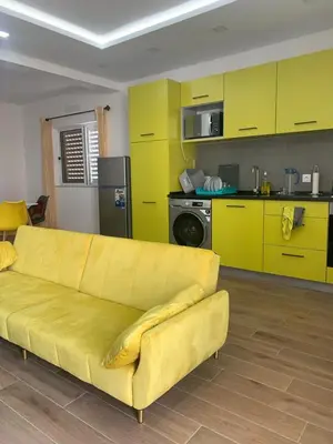 a yellow couch in a kitchen with yellow cabinets at Cantinho PeLe in Mindelo