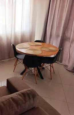 a wooden table and chairs in a living room at Elly Apartamentos in Mindelo