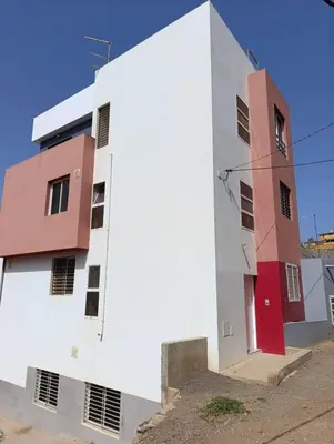 a white building with red and white at Elly Apartamentos in Mindelo