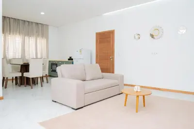 a white living room with a white couch and a table at Your Escape Home in Praia in Praia