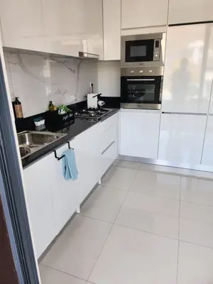 a white kitchen with a sink and a microwave at Boa Mindelo Azul in Mindelo