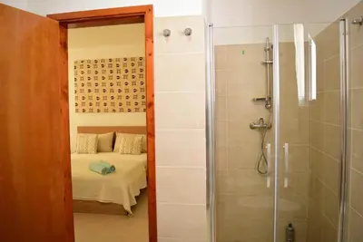 a bathroom with a shower and a bed in a room at Casa Estoril, Boa Vista in Sal Rei