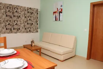 a living room with a couch and a table at Delfim Apartamentos in Praia