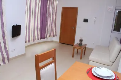 a living room with a couch and a table at Delfim Apartamentos in Praia