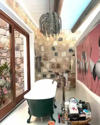 a bathroom with a bath tub and a stone wall at Suite and pool, Praia Estoril, Sal Rei in Sal Rei