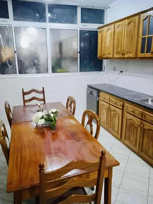 a kitchen with a wooden table with chairs and a table sidx sidx sidx at Conforto de um Lar in Ponta do Sol