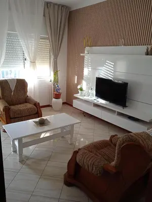 a living room with a tv and a couch and a table at Conforto de um Lar in Ponta do Sol