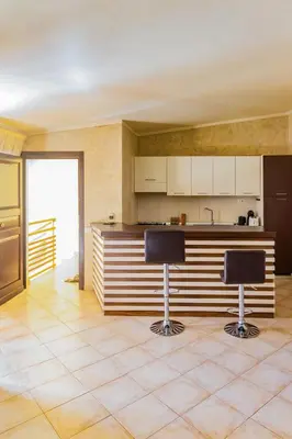 a kitchen with two bar stools in a room at Aparthotel Tropical Bounty Beach T3 in Santa Maria