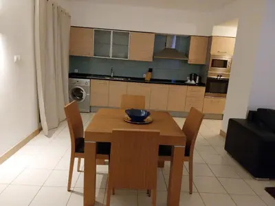 a kitchen and dining room with a wooden table and chairs at Tity Apartments T1 - Perfect Stay on your Holiday in Santa Maria