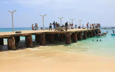 a group of people walking on a pier on the beach at Tity Apartments T1 - Perfect Stay on your Holiday in Santa Maria