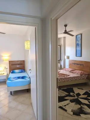 a bedroom with two beds and a ceiling fan at TOP POOL VIEW - Tropical Apt B11 - PointingCaboVerde in Santa Maria