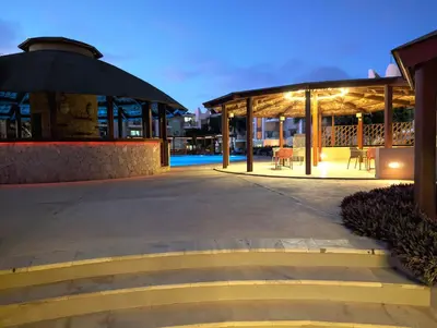 a building with a pavilion with a table and chairs at TOP POOL VIEW - Tropical Apt B11 - PointingCaboVerde in Santa Maria
