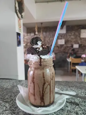 a mason jar of chocolate milkshake on a plate at Techas City Center Luxe Suites in Praia
