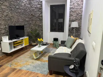 a living room with a couch and a tv at Techas City Center Luxe Suites in Praia