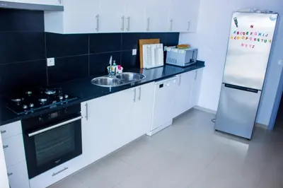 a white kitchen with a sink and a refrigerator at Morabeza & Mar in Porto Novo