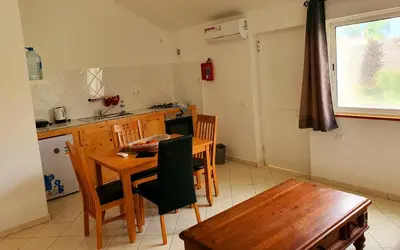 a kitchen with a wooden table and a table and chairs at Capo Verde Club - Ca Matteo in Santa Maria