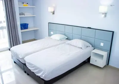 a bedroom with a large bed with white sheets and pillows at Morabeza & Mar in Porto Novo