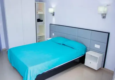 a bedroom with a blue bed in a white room at Morabeza & Mar in Porto Novo