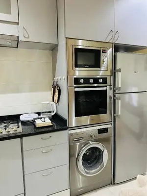 a kitchen with a stainless steel refrigerator and a washing machine at T1 Mindelo City Center in Mindelo