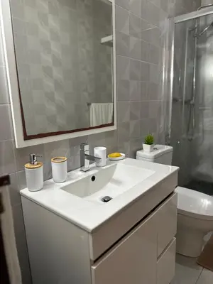 a bathroom with a sink and a toilet and a mirror at T1 Mindelo City Center in Mindelo