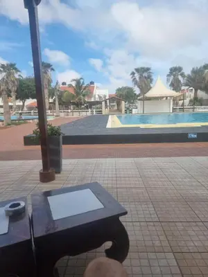 a picnic table in front of a swimming pool at Coral Reef in Santa Maria