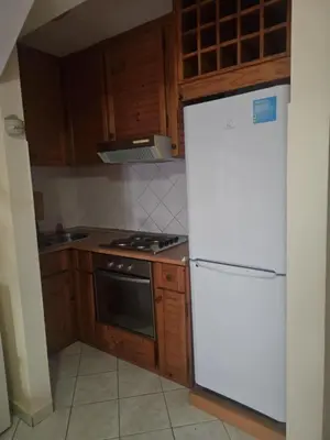 a kitchen with a white refrigerator and wooden cabinets at Coral Reef in Santa Maria