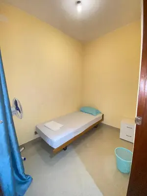 a small room with a bed and a blue curtain at Mar Azul Tarrafal APARTMENT in Tarrafal